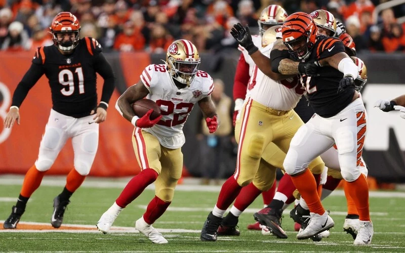Jeff Wilson Jr. #22 of the San Francisco 49ers carries the ball against the defense of the Cincinnati Bengals during the second quarter of the game at Paul Brown Stadium on December 12, 2021 in Cincinnati, Ohio. The Bengals vs 49ers betting odds are already set.