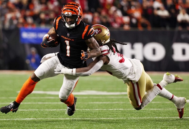 Ja'Marr Chase #1 of the Cincinnati Bengals is tackled on a carry by Marcell Harris #36 of the San Francisco 49ers during the second half of the game at Paul Brown Stadium on December 12, 2021 in Cincinnati, Ohio. The Bengals vs 49ers odds are already set.