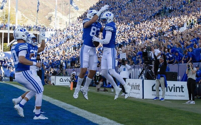 Chase Roberts #2 of the Brigham Young Cougars is congratulated by teammates Isaac Rex #83, Kedon Slovis #10 and LJ Martin #27 during the first half against the Texas Tech Raiders at LaVell Edwards Stadium on October 21 2023 in Provo, Utah. The BYU vs Texas Odds are set for Saturday's game.