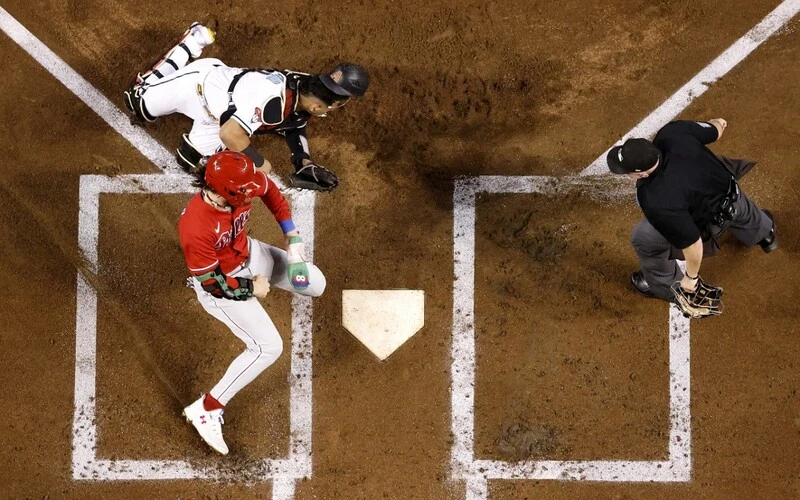 Bryce Harper #3 of the Philadelphia Phillies checks on Gabriel Moreno #14 of the Arizona Diamondbacks after colliding at home plate to score a run during the first inning in Game Five of the National League Championship Series at Chase Field on October 21, 2023 in Phoenix, Arizona. The Phillies vs Diamondbacks Odds are set for tonight's game.