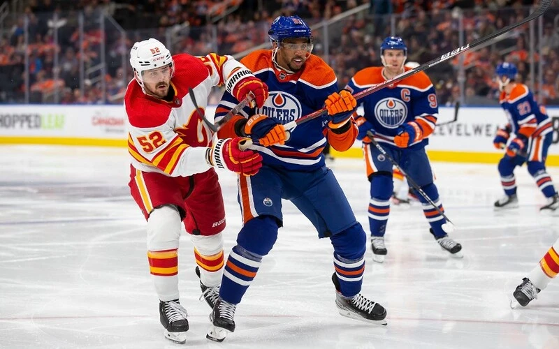 Evander Kane #91 of the Edmonton Oilers battles against MacKenzie Weegar #52 of the Calgary Flames during the second period at Rogers Place on October 15, 2022 in Edmonton, Canada. The Flames vs Oilers Odds are already set.
