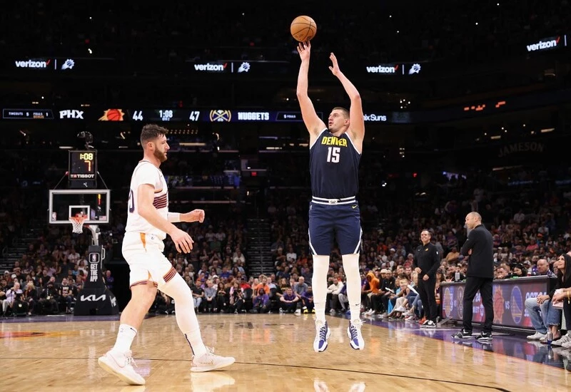 Nikola Jokic #15 of the Denver Nuggets attempts a shot over Jusuf Nurkic #20 of the Phoenix Suns during the NBA game at Footprint Center on October 10, 2023 in Phoenix, Arizona. The NBA Season starts with the Lakers vs Nuggets Betting Odds.