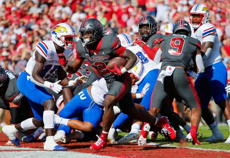 Running back Jovantae Barnes #2 of the Oklahoma Sooners scores on a one-yard run off a block by tight end Brayden Willis #9 against the Kansas Jayhawks in the first quarter at Gaylord Family Oklahoma Memorial Stadium on October 15, 2022 in Norman, Oklahoma. Oklahoma won 52-42. The Oklahoma vs Kansas Odds are set.
