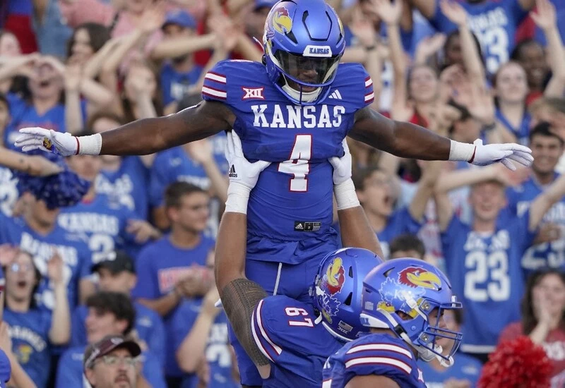 Running back Devin Neal #4 of the Kansas Jayhawks is lifted into the air by offensive lineman Dominick Puni #67 after scoring a touchdown in the first half against the Missouri State Bears at David Booth Kansas Memorial Stadium on September 01, 2023 in Lawrence, Kansas. The Oklahoma vs Kansas Odds are set.