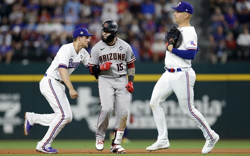 Corey Seager #5 of the Texas Rangers tags out Emmanuel Rivera #15 of the Arizona Diamondbacks during a rundown in the ninth inning during Game Two of the World Series at Globe Life Field on October 28, 2023 in Arlington, Texas. The Rangers vs D-backs Predictions are ready for tonight's Game 3 in Phoenix.