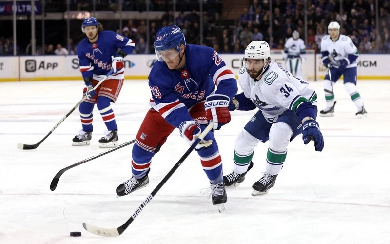 Adam Fox #23 of the New York Rangers controls the puck as Phillip Di Giuseppe #34 of the Vancouver Canucks chases during the 1st period of the game at Madison Square Garden on February 08, 2023 in New York City. The Rangers vs Canucks Odds are already set.