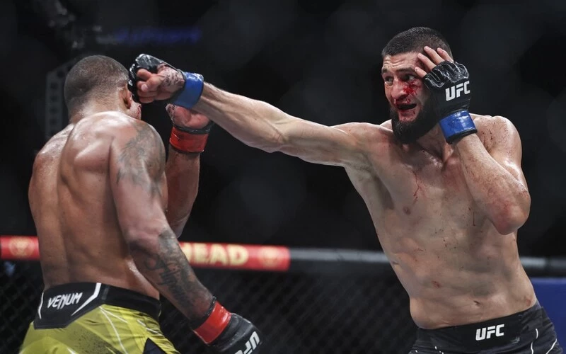 Khamzat Chimaev of Russia punches Gilbert Burns of Brazil in the welterweight bout during the UFC 273. The Usman vs Chimaev Prediction is a close one.